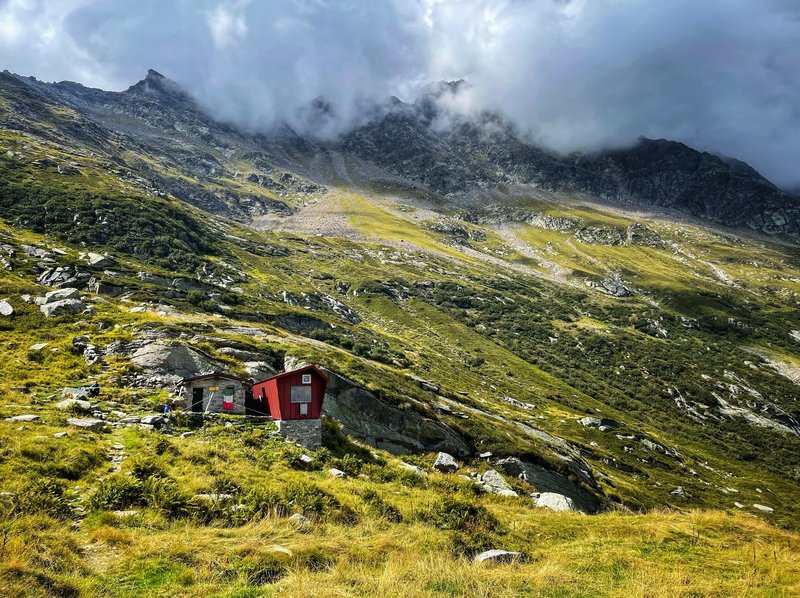 De hut met het rode dak onder de wolken